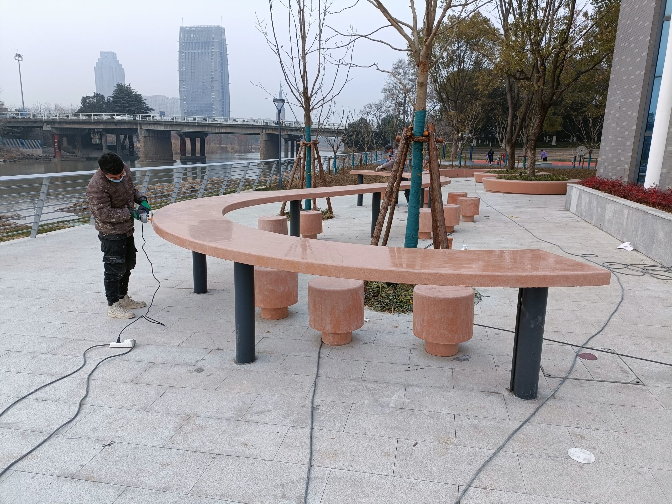 河畔的暖调弧度 —— 阿尔博艺术混凝土橙系坐凳,让户外社交有了温度